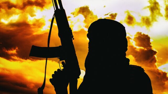 Muslim,Militant,With,Rifle,In,The,Desert,On,Sunset,With