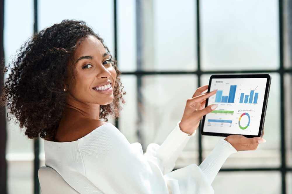 Smiling,Business,Woman,With,A,Digital,Tablet,Looking,At,The