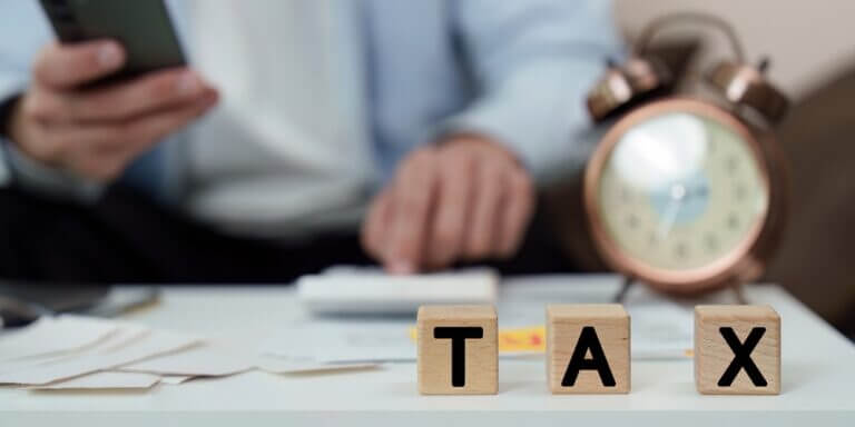 Tax,Filing.,Individual,Managing,Tax,Blocks,And,Paperwork,With,Clock.