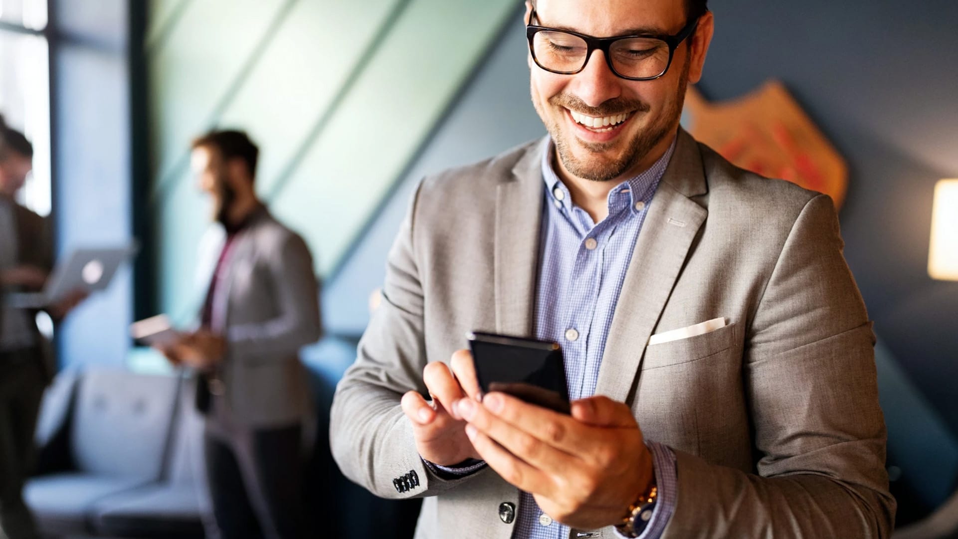 Workspace Collaboration, persona che guarda lo smartphone in ufficio