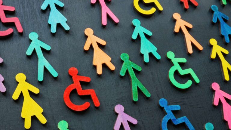 Accessibilità digitale: concept diversità e inclusione. Figurine colorate su sfondo nero.